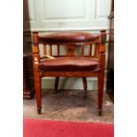 An Arts and Crafts oak captains chair, with red leather padded back and arms, with an upholstered