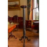 A George II style mahogany torchere, the circular top raised on a spiral turned and acanthus carved