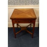 An Edwardian mahogany envelope card table, the top swivelling round to reveal well and opening out