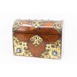A late 19th century burr walnut domed stationery box, with brass strap work and blue cabochons.
