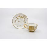 An Aesthetic Movement tea cup and saucer, probably Minton, the cup with a hand painted polychrome