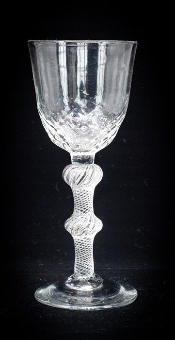 An 18th century balustroid wine glass, circa 1750, the optic moulded round funnel bowl, with