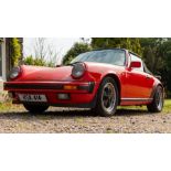 A 1985 Porsche 911 convertible sports car, 3164cc engine, guards red livery, black canvas tonneau,
