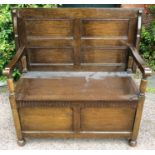 A 20th Century oak Monks bench, panelled back, lidded seat, enclosing storage section, 102cm high,