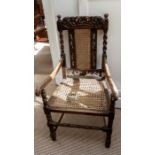 A late Victorian Carolean revival style oak open armchair, the carved crest rail depicting a Crown