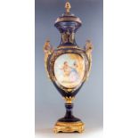 A large 20th Century decorative twin handled covered vase in the manner of Sevres, painted with an