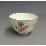 A Chelsea Derby tea bowl, ogee shaped painted with roses and floral sprigs, gilt dentil border,