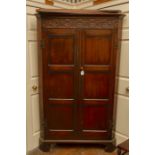 A 19th Century oak free standing corner cupboard, the cornice carved with rosettes and roundels,