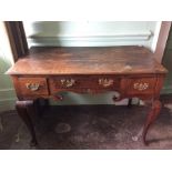 A George II oak lowboy, fitted with three drawers, pierced apron piece, raised on cabriole legs,