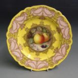 A Royal Worcester cabinet plate, deep yellow ground with a border of pink and gilt, the centre