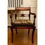 A Regency mahogany elbow chair, the back with carved roundel to the centre rail, floral needlework s