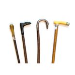 four walking canes, one with white metal canine head handle, (one eye missing), one with carved boot