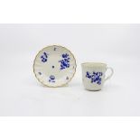 A Worcester fluted coffee cup and saucer, decorated in 'The Giles' manner with 'dry blue' flowers,
