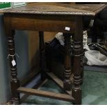 A late Victorian oak carved gate leg table of triangular form