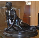 A 19th Century cast bronze figure of a reclining Classical lady, holding a shell,