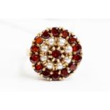 A 9ct gold garnet and pearl set circular dress ring, diameter approx 1.