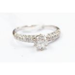 An 18ct white gold and diamond ring, claw set round-cut diamond to the centre approx 0.