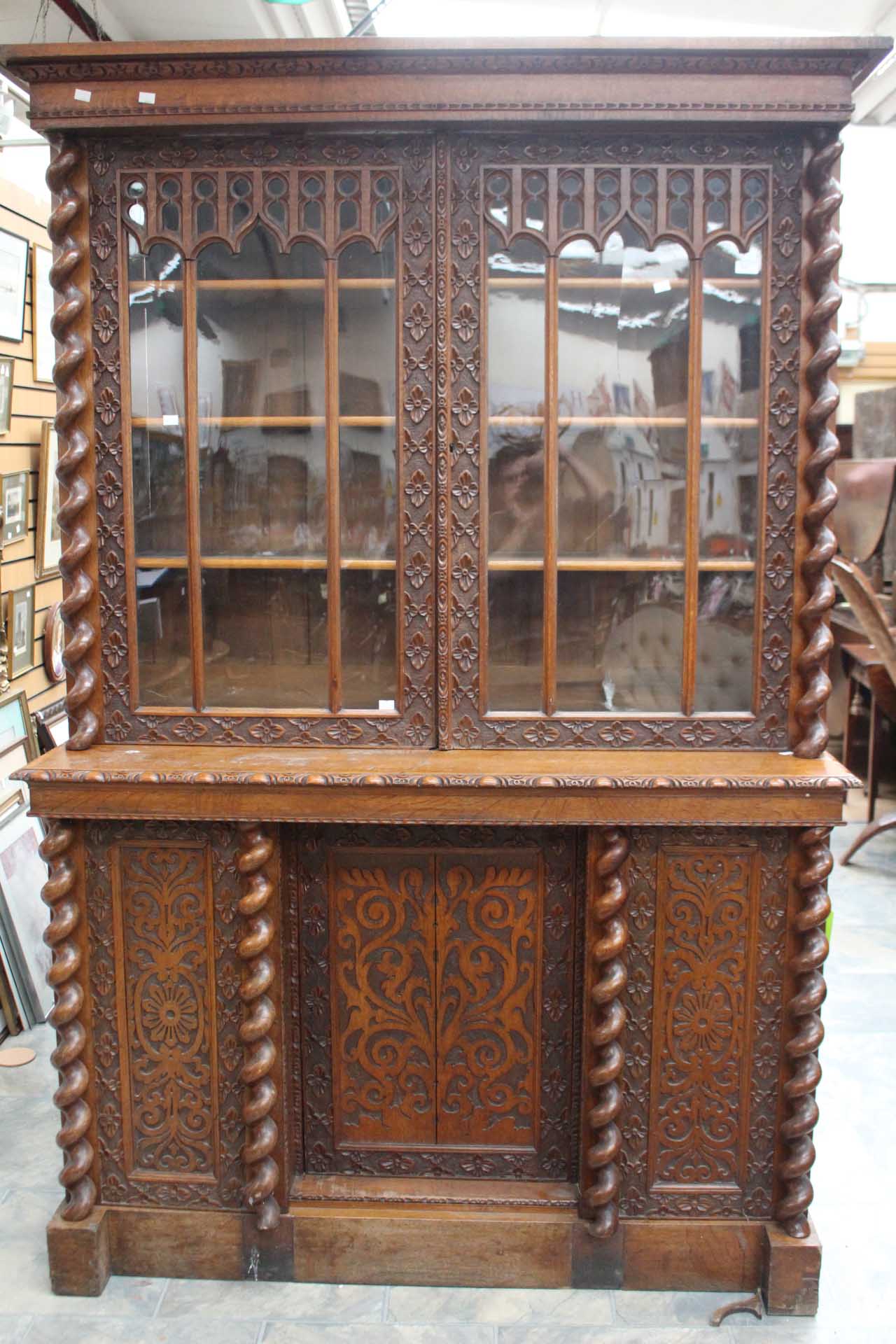 A mid 19th Century oak bookcase, of two-tier form, carved throughout,