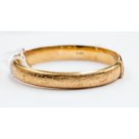 A 9ct yellow gold bangle, engraved leafage scrolls, sponsors mark, "B Ltd",