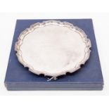 An Elizabeth II silver presentation salver, shaped border on four scroll feet,