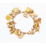 A 9ct gold charm bracelet with various charms, including acorn, English rose and cow etc,