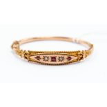 A Victorian 9ct gold bangle set with diamonds and red paste stones, rope border,