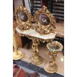 A resin pot stand, figure of a cherub holding pot, gilt, with a pair of gilt decorative shelves,