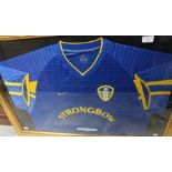 A framed, glazed and signed Leeds United away shirt, bearing Robbie Keane's signature,