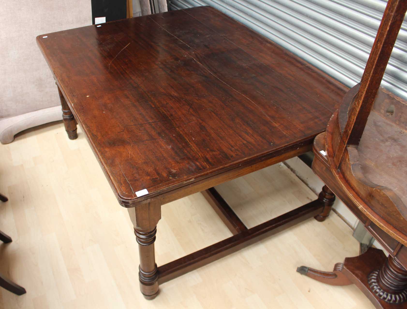 An early 20th century solid mahogany dining table,
