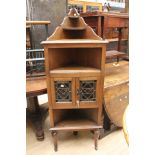 A small three tier oak corner cupboard with glazed doors,