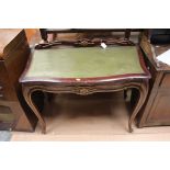 An early 20th Century beech and gilded leather inset writing table,