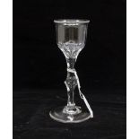 A George III cut glass wine glass, circa 1780, having a lipped bowl, facet cut and knopped stem,