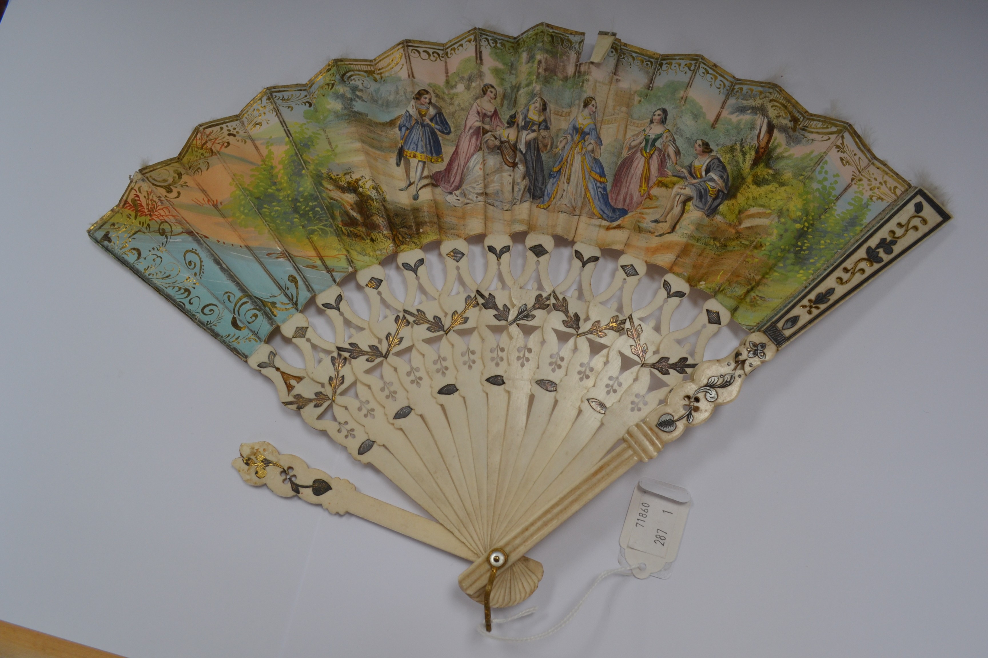 An 18th Century hand-painted and ivory fan, the sticks and guards pierced and gilded,