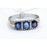 A three stone sapphire and diamond ring, comprising three oval mixed cut sapphires set in 14ct gold,
