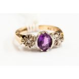 A 9ct gold and amethyst ring, white gold setting with two diamond chips, size I,