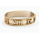 A 9ct gold two tone bangle white gold with applied yellow gold Roman numerals and yellow gold edges,