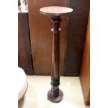 A 20th Century mahogany torchere, the top raised on a circular column,