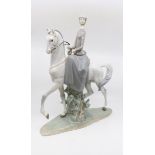 A large Lladro figurine of a lady riding a grey stallion,