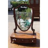 A George III Mahogany shield shape dressing mirror, circa 1820, three small drawers to base.