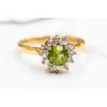 A 18ct gold diamond and peridot cluster ring, round central peridot with diamond surround, size N½,