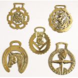 A collection of five horse brasses; one depicting Churchill's head in profile;