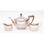A Victorian silver oval semi fluted teapot and sugar and milk (different hallmarks)