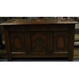 A mid 20th Century oak coffer with carved front panels