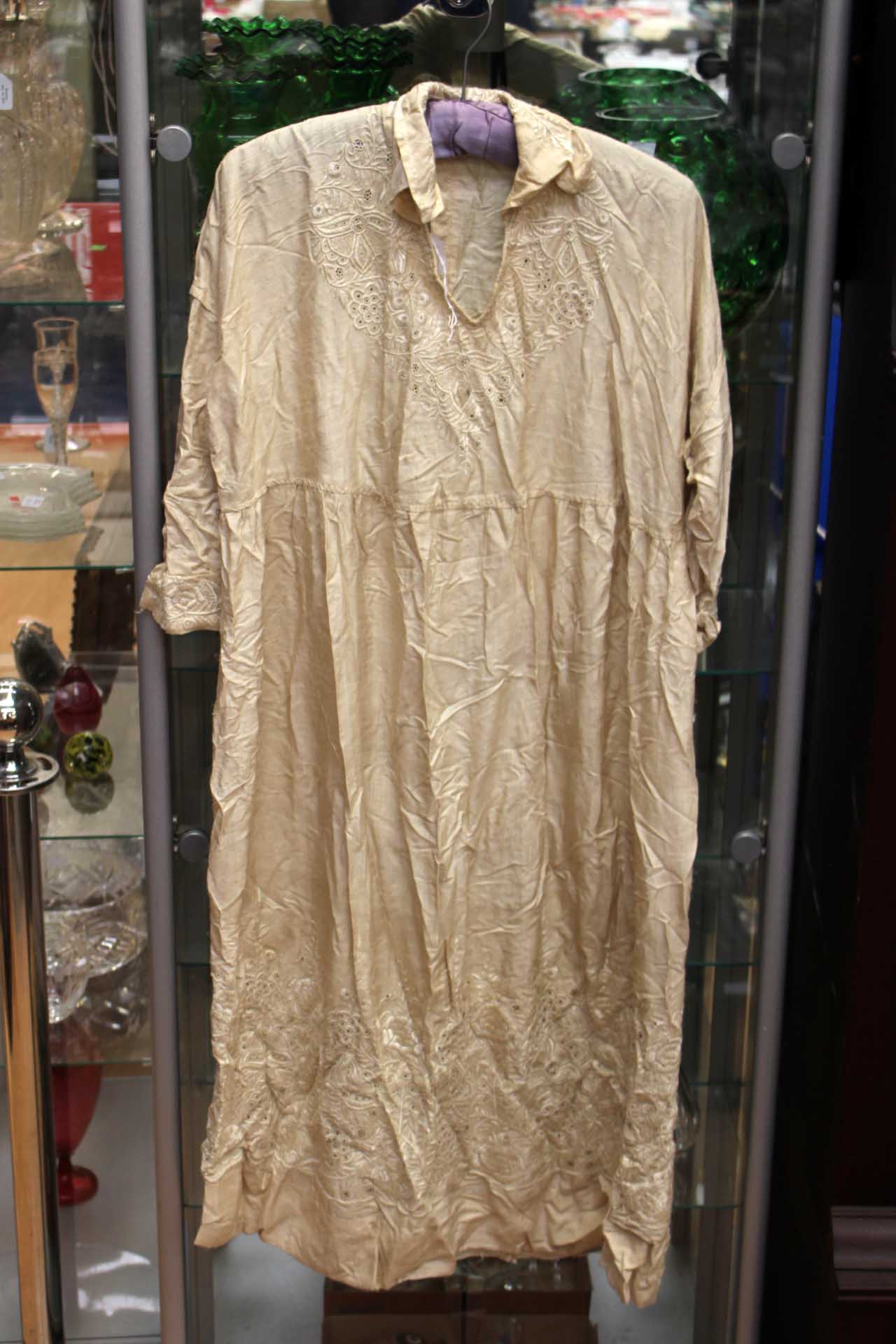 A late Edwardian cream silk ladies dress with a self embroidered pattern of flowers and foliage,