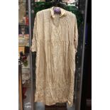 A late Edwardian cream silk ladies dress with a self embroidered pattern of flowers and foliage,