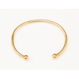 A 9ct gold torque bangle, ball ends, weight approx. 14.8gms.