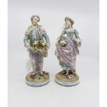 A pair of German Sitzendorf porcelain figures in 18th Century dress with birds,