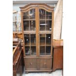 An early 20th Century display cabinet with two doors at the bottom