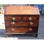 A George III oak and mahogany cross-banded bureau, the fall front enclosing a fitted interior,
