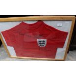 An England red shirt, signed, framed and glazed, Geoff Hurst, Martin Peters and George Cohen,